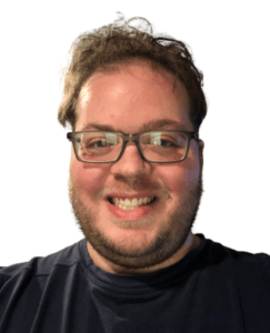 Close-up portrait of a person with glasses wearing a black t-shirt, featuring a warm smile and casual appearance
