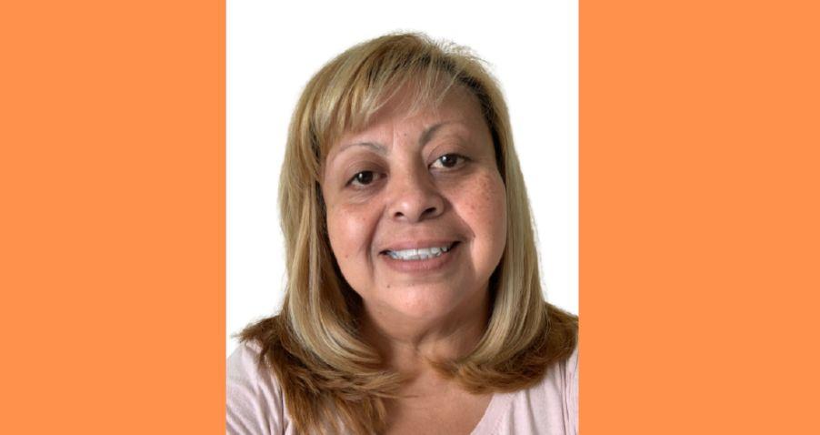 Professional headshot of a woman with blonde hair and warm smile against white background with orange border