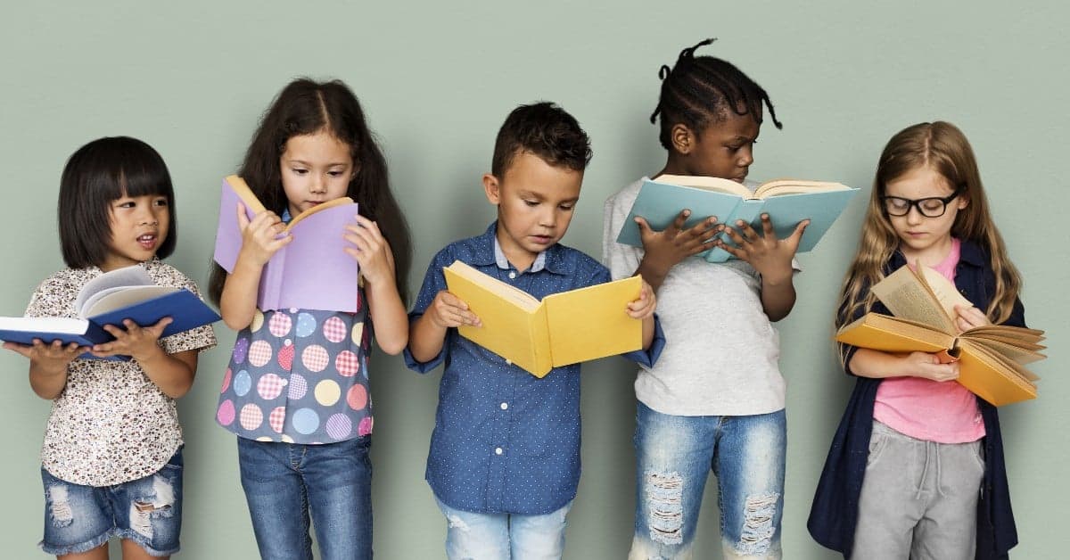 Five diverse elementary school children standing in a row against a wall, each absorbed in reading their own books