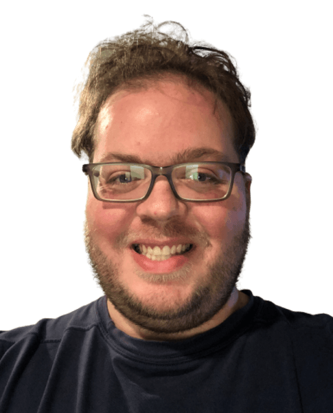 Portrait of person with glasses wearing black shirt, showing genuine smile against neutral background